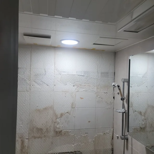 욕실벽타일교체 중 타일을 떼어내고 접착제 자국이 남은 욕실 벽 바탕